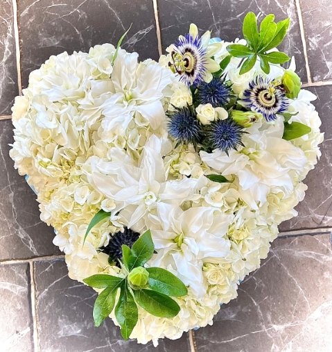 A bead of white hydrangea with a sprinkle of lilies coupled pops of the florist choice of the day